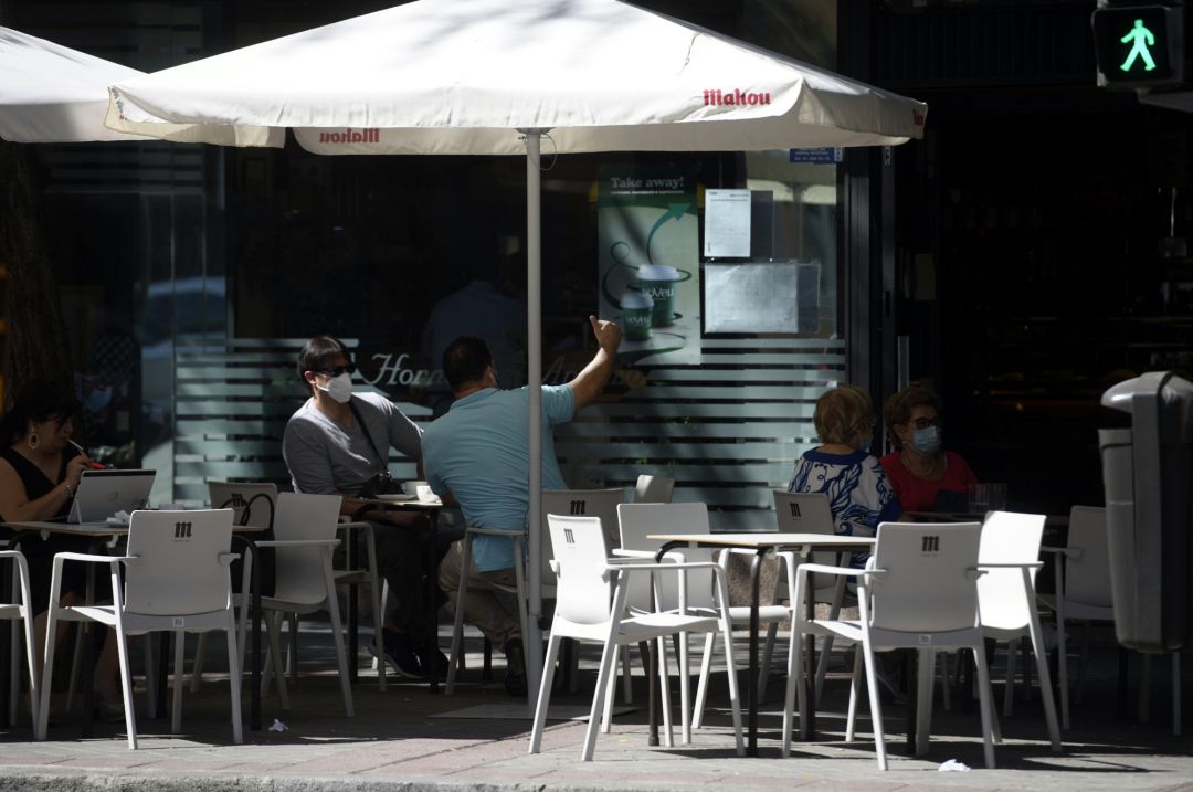 Varias personas disfrutan en una terraza Varias personas disfrutan en una terraza