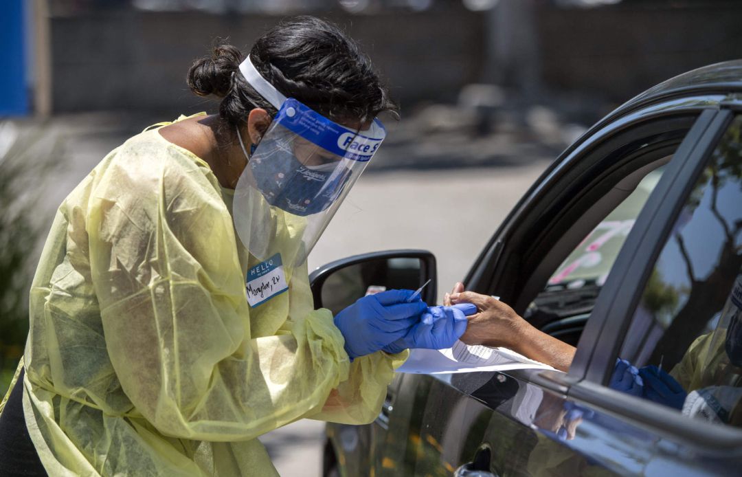 Una asistente sanitaria realiza una prueba de coronavirus a una persona desde el interior de su vehículo en Los Ángeles, Estados Unidos. Una asistente sanitaria realiza una prueba de coronavirus a una persona desde el interior de su vehículo en Los Ángeles, Estados Unidos.
