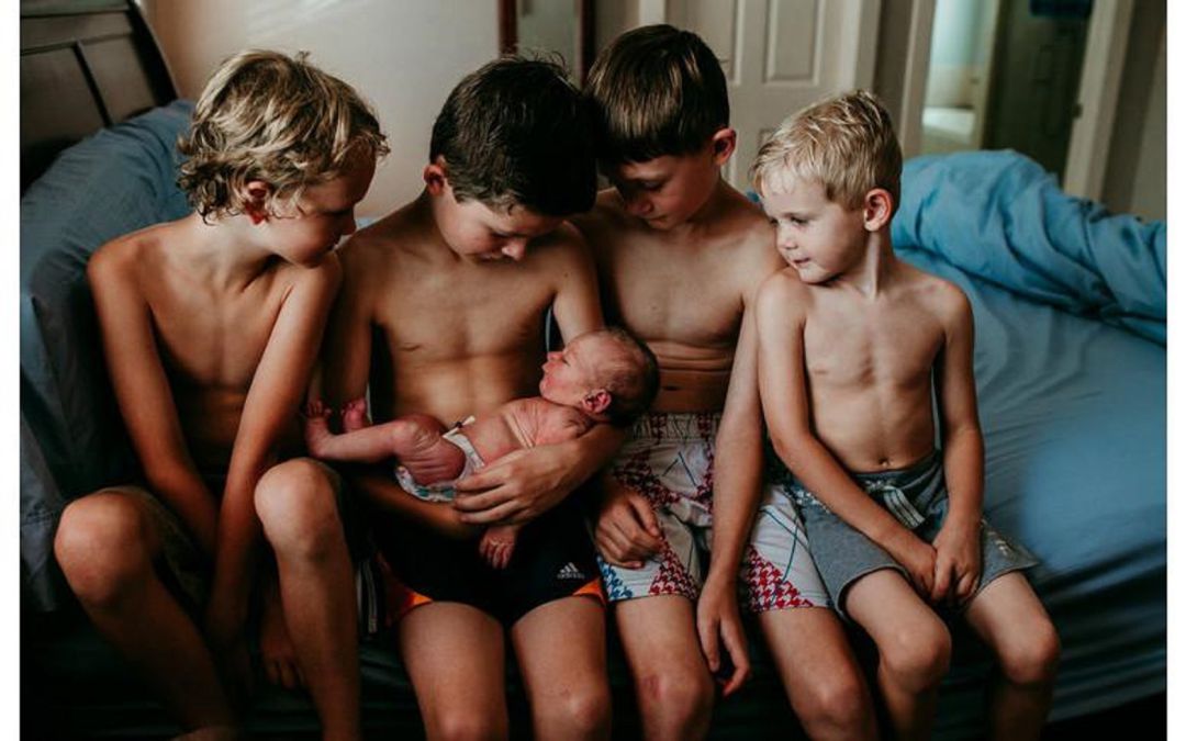 Unos niños cuidan a un recién nacido. fotografía premiada en un concurso Unos niños cuidan a un recién nacido. fotografía premiada en un concurso