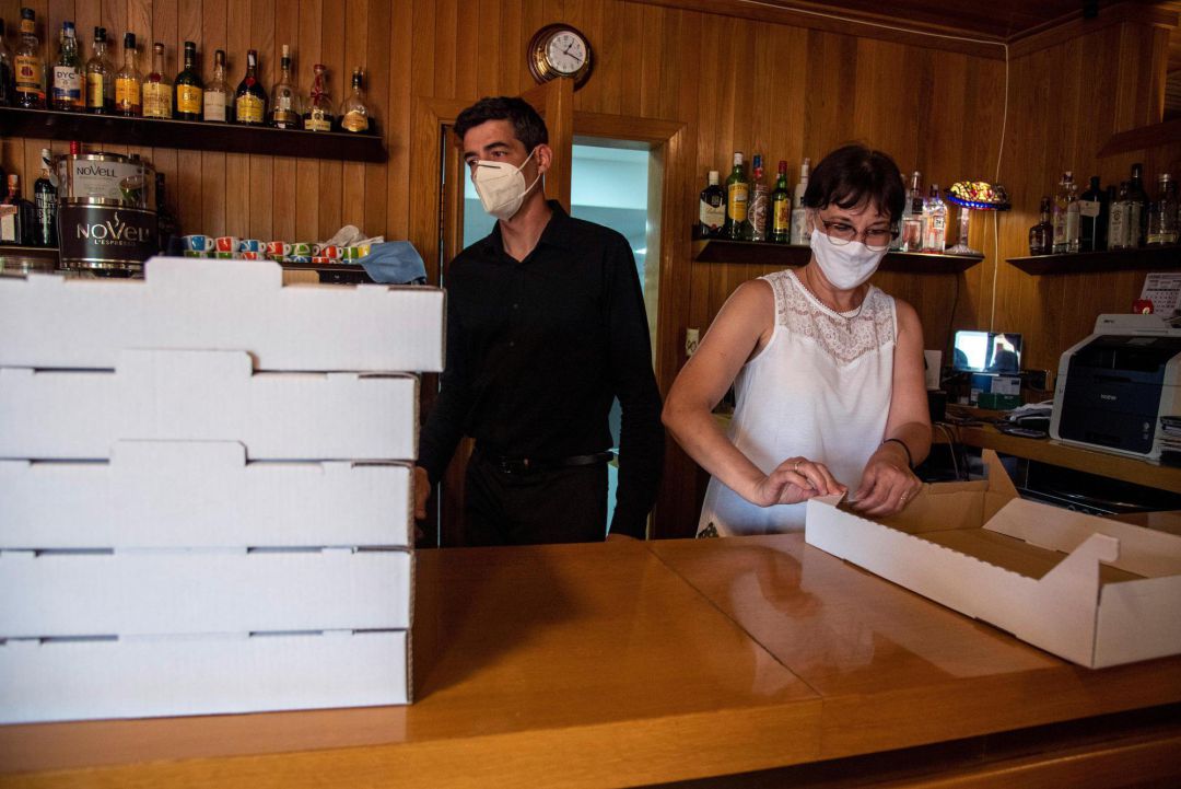 Dos camareros preparan cajas de comida para llevar tras conocerse que la Generalitat aplicará a partir de esta medianoche un confinamiento domiciliario parcial a los habitantes de Lleida Dos camareros preparan cajas de comida para llevar tras conocerse que la Generalitat aplicará a partir de esta medianoche un confinamiento domiciliario parcial a los habitantes de Lleida