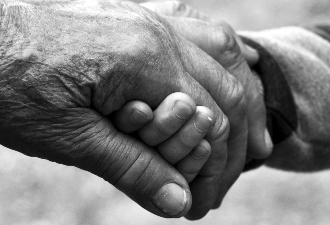 Un abuelo agarra la mano de su nieto Un abuelo agarra la mano de su nieto