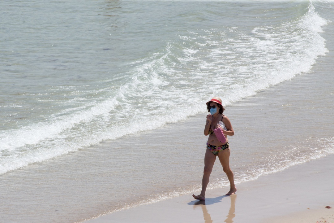 Una mujer protegida con mascarilla pasea por la Playa de A Rapadoira en Foz, en la comarca de A Mariña, Lugo Una mujer protegida con mascarilla pasea por la Playa de A Rapadoira en Foz, en la comarca de A Mariña, Lugo