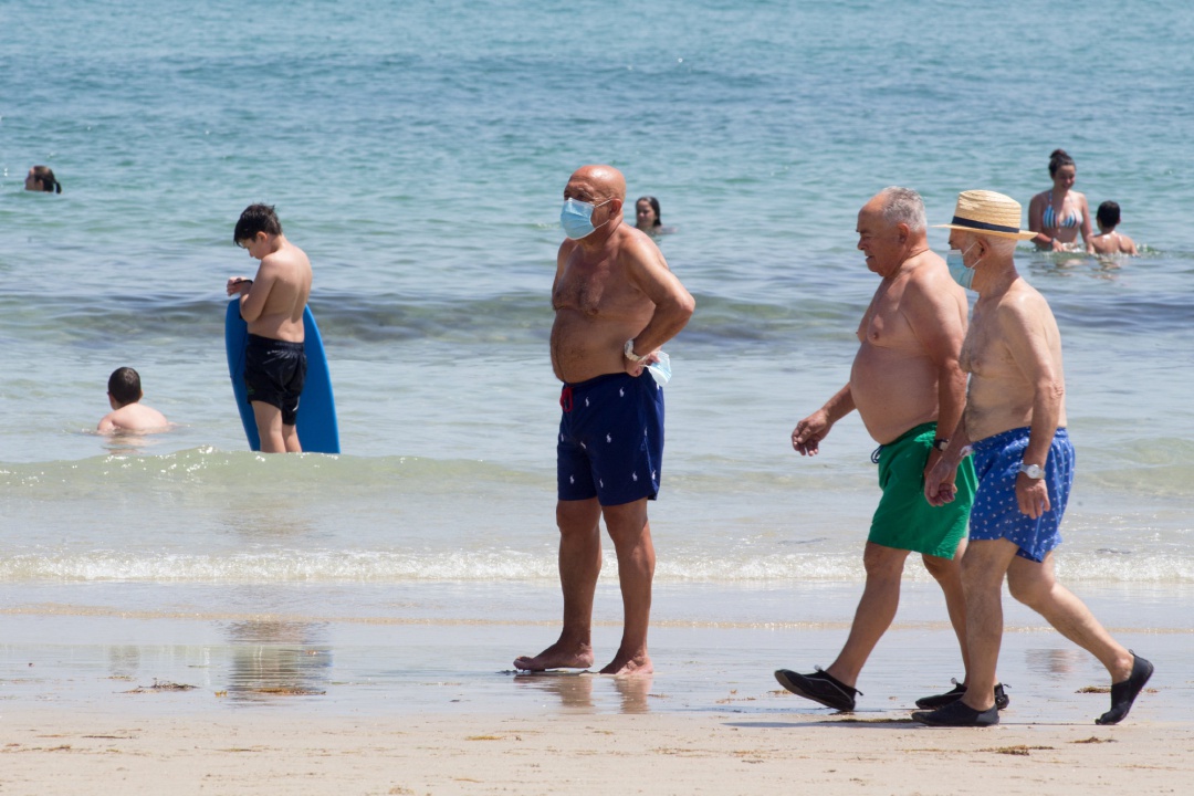 Tres hombres protegidos con mascarillas pasean por la Playa de A Rapadoira en Foz, en la comarca de A Mariña. Tres hombres protegidos con mascarillas pasean por la Playa de A Rapadoira en Foz, en la comarca de A Mariña.
