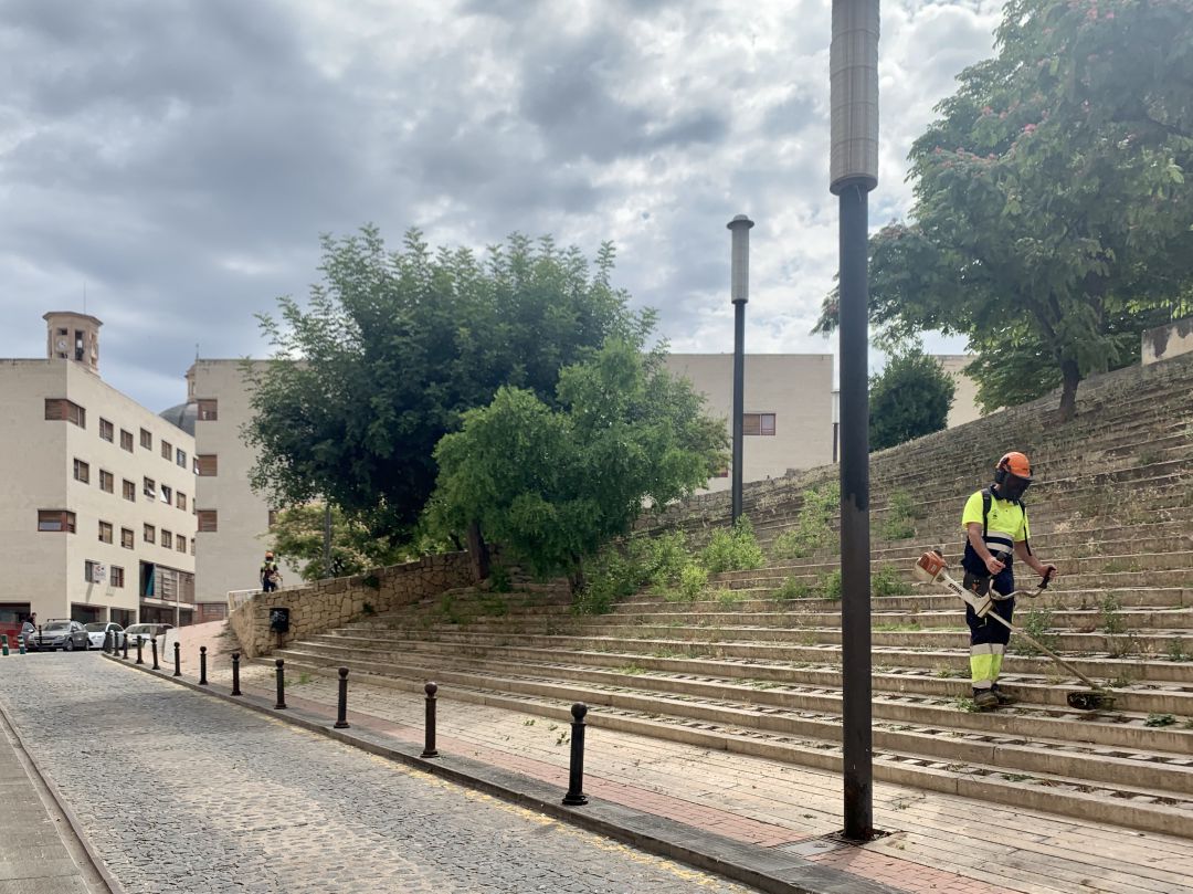 Un operario cortando la hierba en los tramos de hormigón situados en la calle Sant Domènec. Un operario cortando la hierba en los tramos de hormigón situados en la calle Sant Domènec.