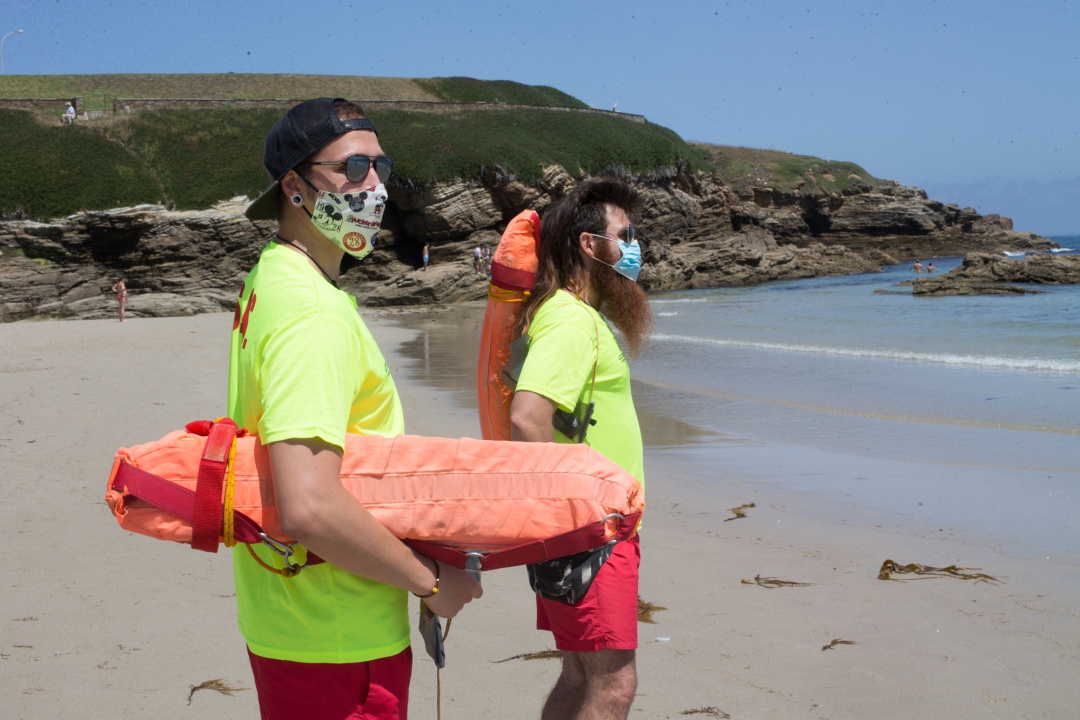 Dos socorristas protegidos con mascarilla vigilan la Playa de A Rapadoira en Foz, en la comarca de A Mariña, Lugo Dos socorristas protegidos con mascarilla vigilan la Playa de A Rapadoira en Foz, en la comarca de A Mariña, Lugo