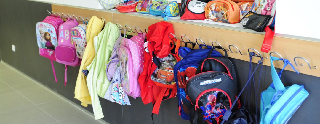 Mochilas en los percheros de un colegio Mochilas en los percheros de un colegio