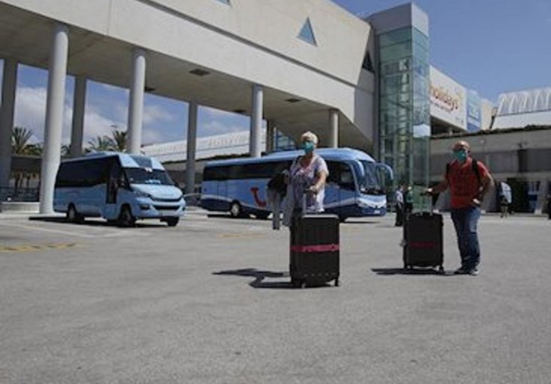 Pasajeros llevando sus maletas en el parquing de autobuses de Son Sant Joan Pasajeros llevando sus maletas en el parquing de autobuses de Son Sant Joan