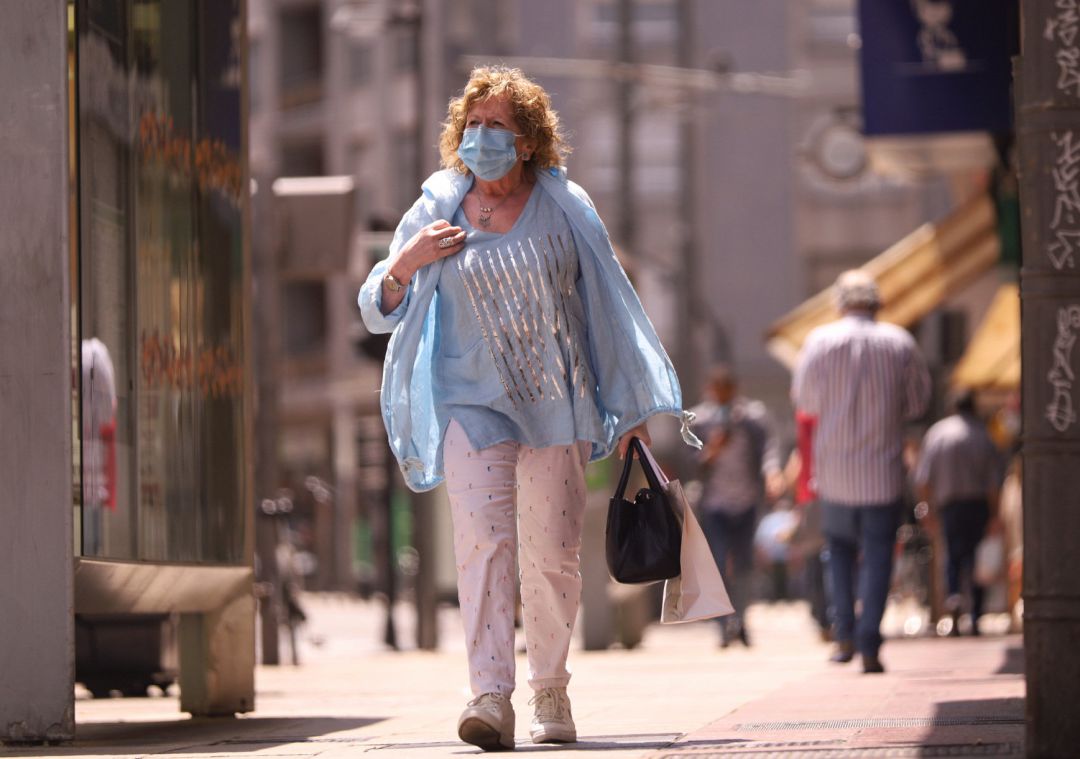 Una mujer pasea con mascarilla. Una mujer pasea con mascarilla.