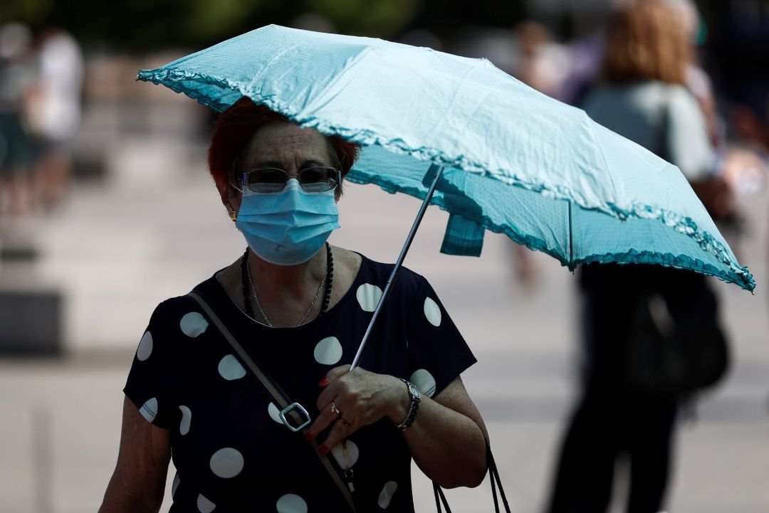 Una mujer pasea por el centro de la capital protegida con una sombrilla, este jueves. Una mujer pasea por el centro de la capital protegida con una sombrilla, este jueves.