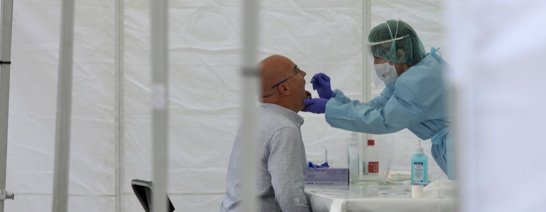 Una sanitaria le realiza un frotis bucal a un vecino Una sanitaria le realiza un frotis bucal a un vecino