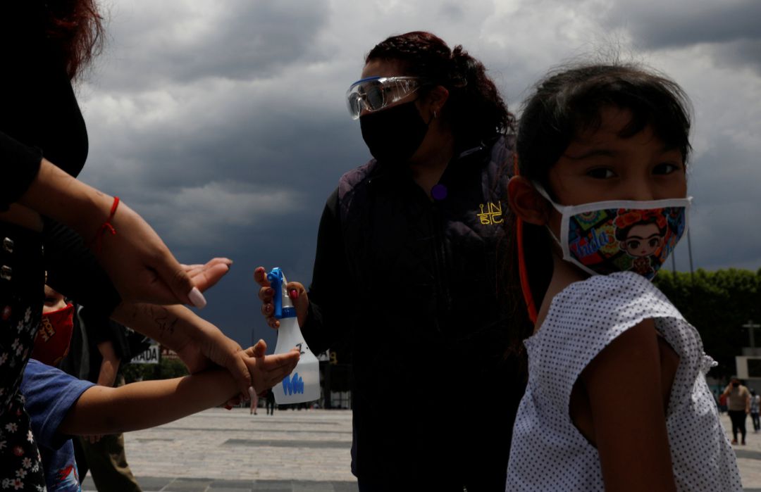 Una niña con mascarilla espera para que personal de servicio le reparta gen desinfectante a las puertas de la Basílica de Guadalupe, en Ciudad de Mexico. Una niña con mascarilla espera para que personal de servicio le reparta gen desinfectante a las puertas de la Basílica de Guadalupe, en Ciudad de Mexico.