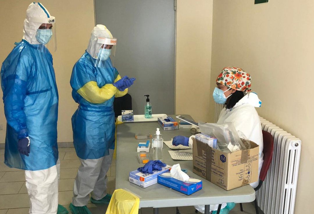Dos profesionales sanitarios realizan una prueba PCR a una persona. Dos profesionales sanitarios realizan una prueba PCR a una persona.
