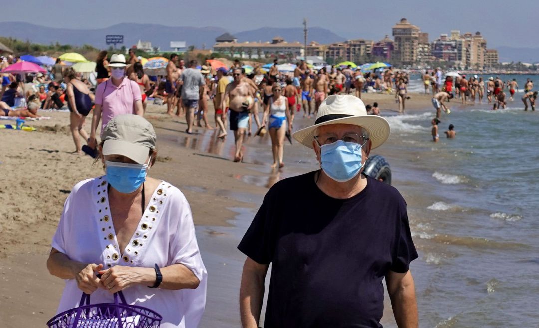 Dos personas pasean, este domingo, por la orilla de la playa de La Patacona de Alboraia protegidos con mascarillas Dos personas pasean, este domingo, por la orilla de la playa de La Patacona de Alboraia protegidos con mascarillas