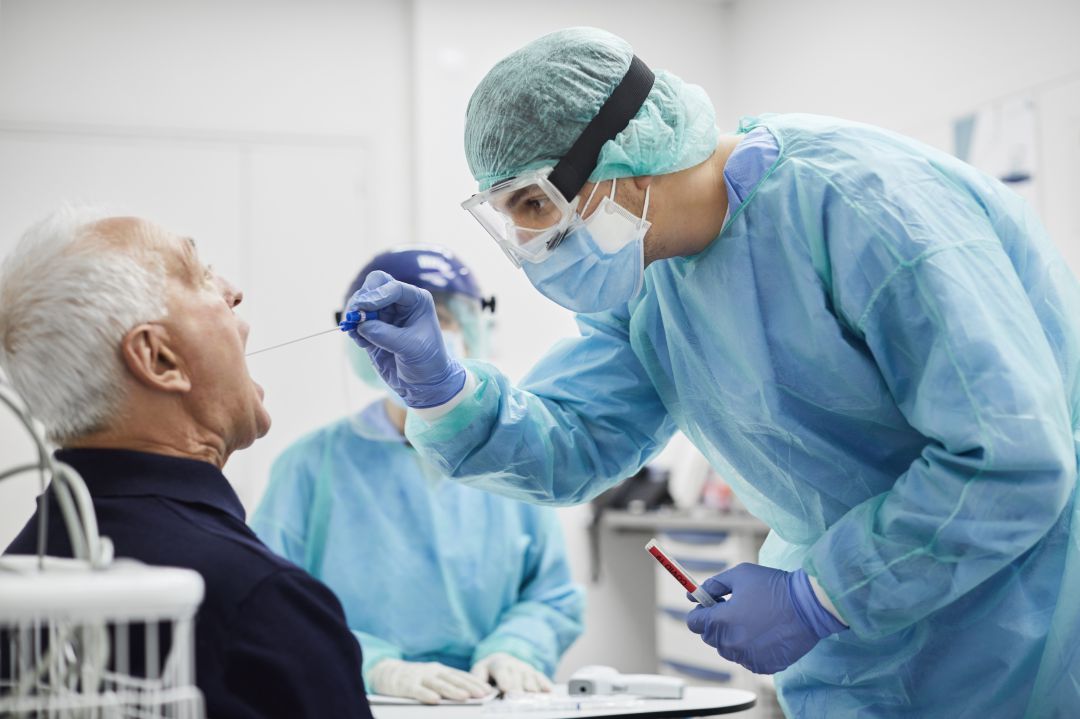 Un sanitario toma muestras a un paciente para una prueba PCR Un sanitario toma muestras a un paciente para una prueba PCR