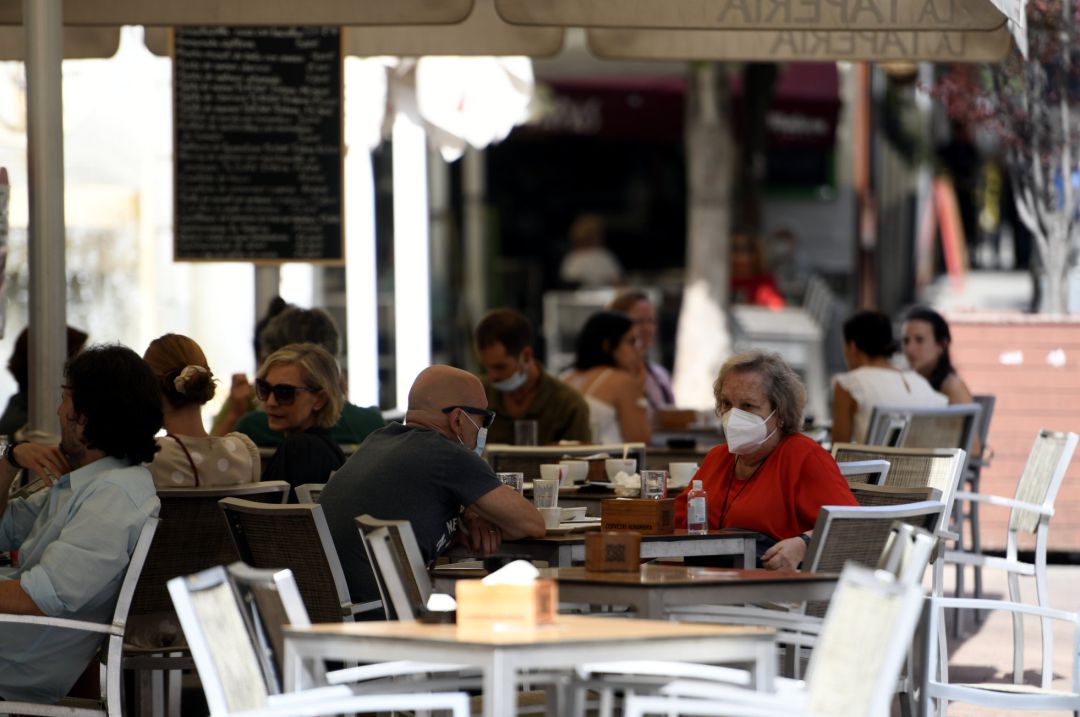 Varias personas se toman una consumición en la terraza de un bar. Varias personas se toman una consumición en la terraza de un bar.