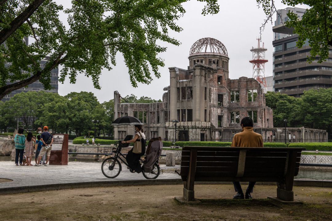 Una mujer viaja en bicicleta por el Atomic Bomb Dome, en Hiroshima Una mujer viaja en bicicleta por el Atomic Bomb Dome, en Hiroshima