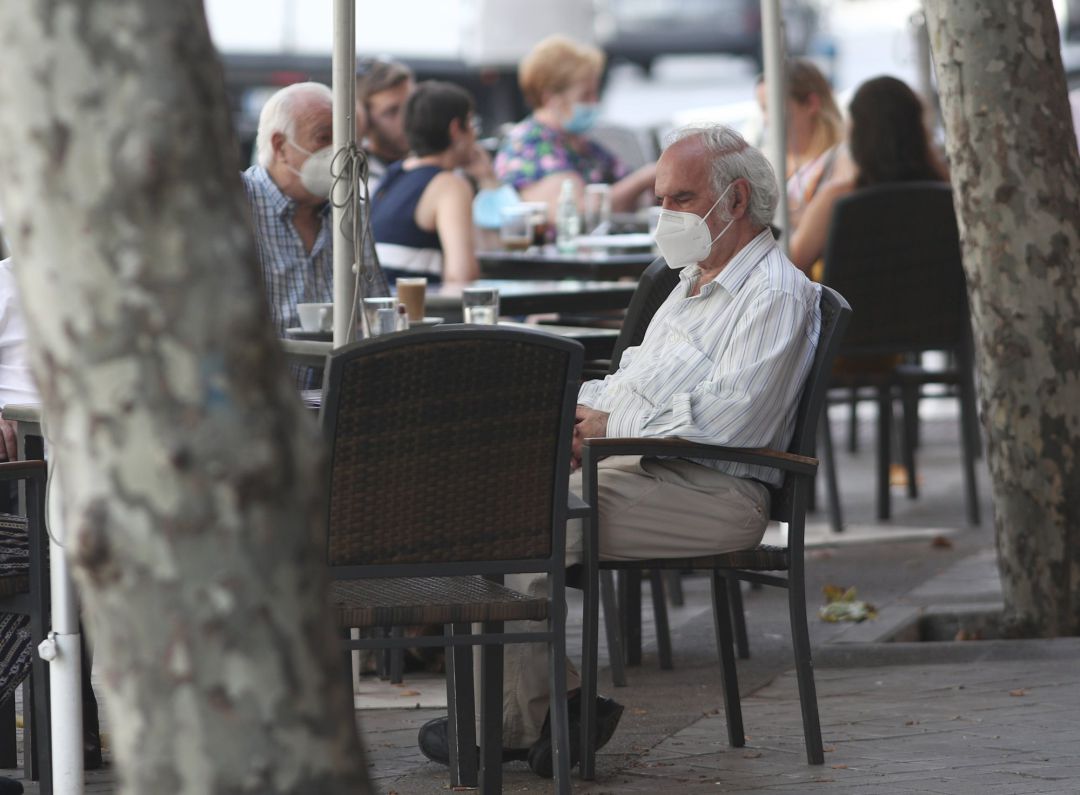 Varias personas disfrutan en una terraza Varias personas disfrutan en una terraza