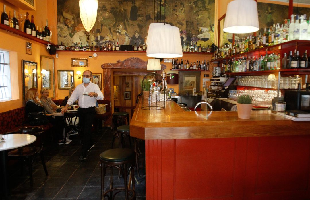 Un camarero sirve una mesa en un bar. Un camarero sirve una mesa en un bar.
