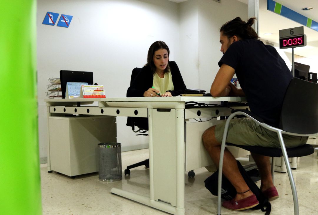 Un ciutadà atén les explicacions d'una treballadora del Servei d'Ocupació de Catalunya Un ciutadà atén les explicacions d'una treballadora del Servei d'Ocupació de Catalunya