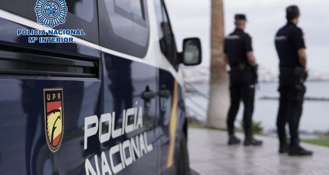 Agentes de la Policía Nacional junto a un coche patrulla Agentes de la Policía Nacional junto a un coche patrulla