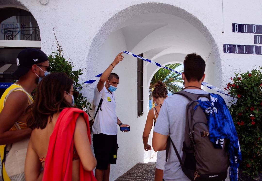 Un auxiliar de playa de la Junta de Andalucía (i), permite el acceso a bañistas a la playa de Papagayo en Nerja (Málaga) Un auxiliar de playa de la Junta de Andalucía (i), permite el acceso a bañistas a la playa de Papagayo en Nerja (Málaga)
