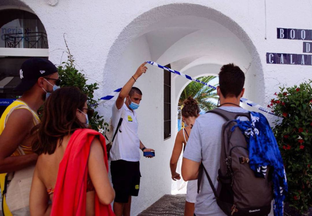 Un auxiliar de playa de la Junta de Andalucía (i), permite el acceso a bañistas a la playa de Papagayo en Nerja (Málaga) Un auxiliar de playa de la Junta de Andalucía (i), permite el acceso a bañistas a la playa de Papagayo en Nerja (Málaga)
