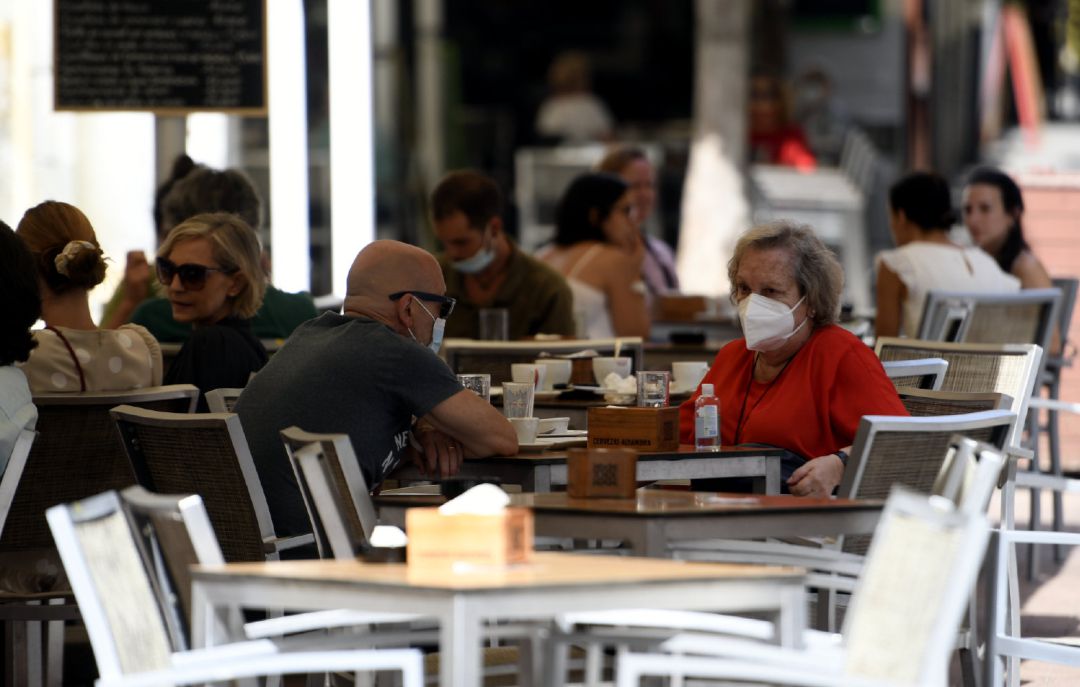 Varias personas disfrutan en una terraza de un bar Varias personas disfrutan en una terraza de un bar