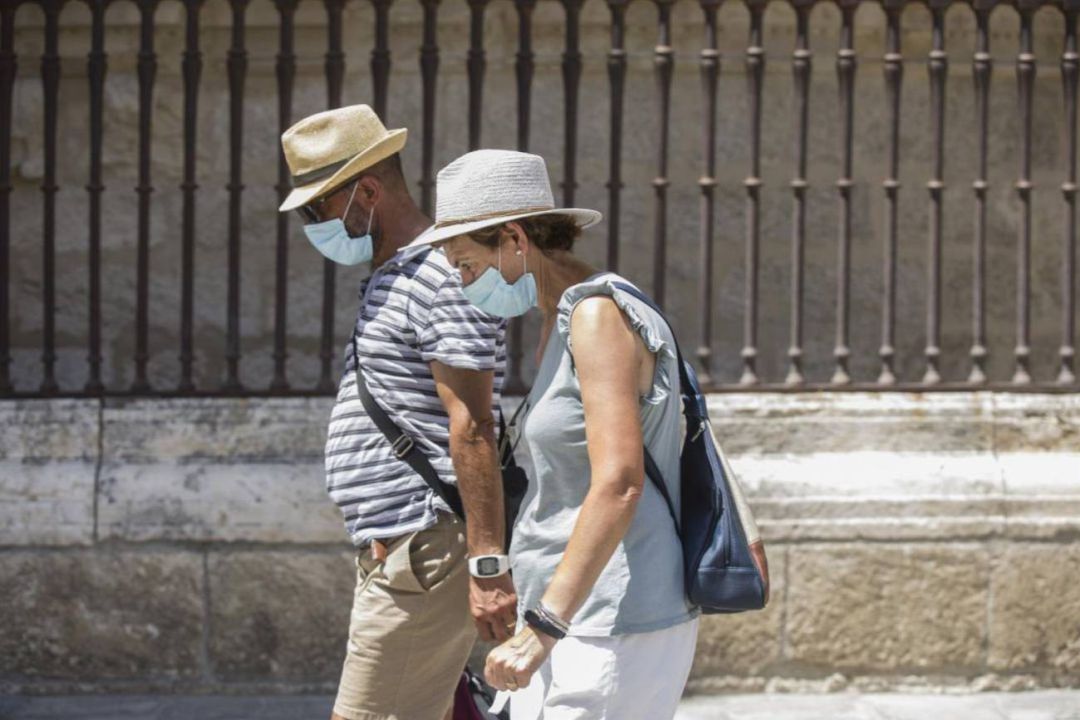 Una pareja pasea con mascarilla Una pareja pasea con mascarilla