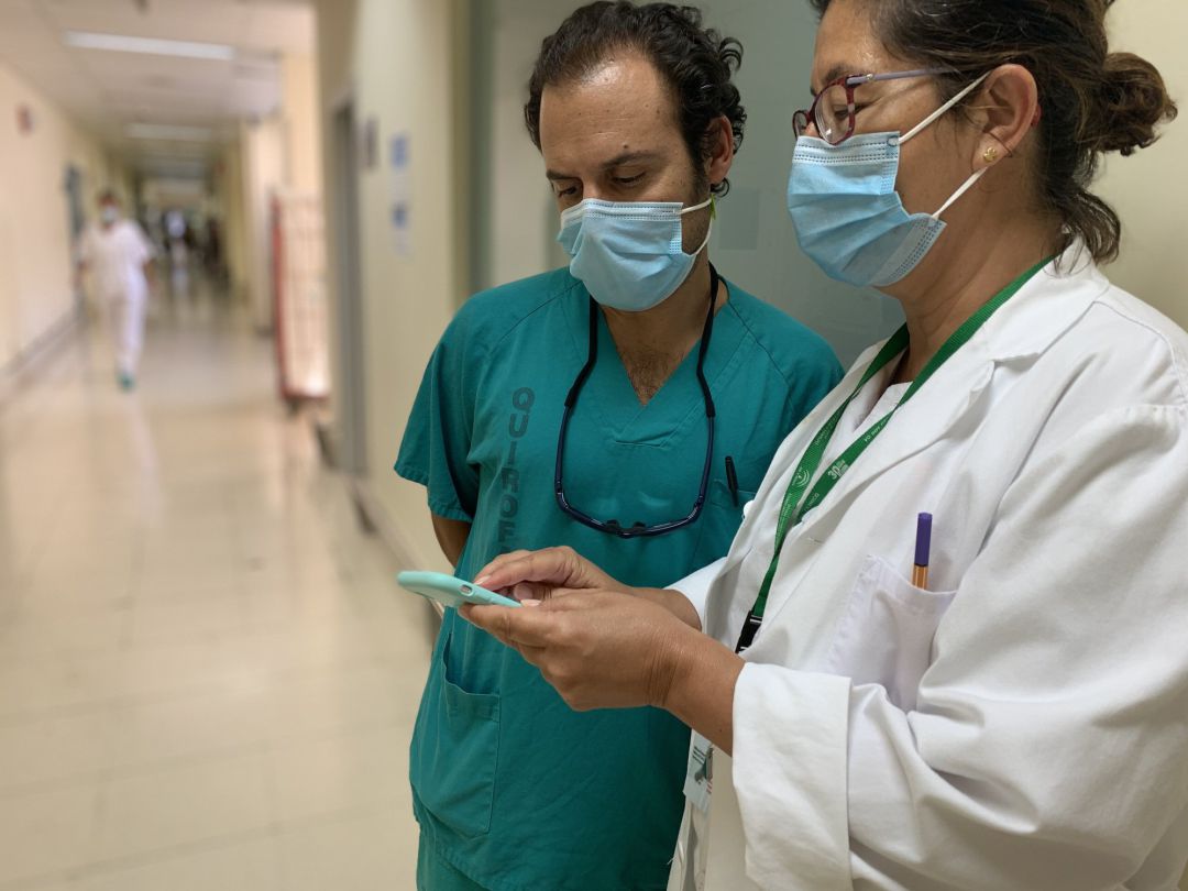 Dos profesionales sanitarios consultan un teléfono móvil
Dos profesionales sanitarios consultan un teléfono móvil