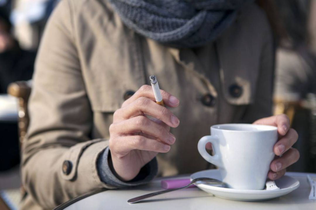 Mujer fumando en una terraza Mujer fumando en una terraza