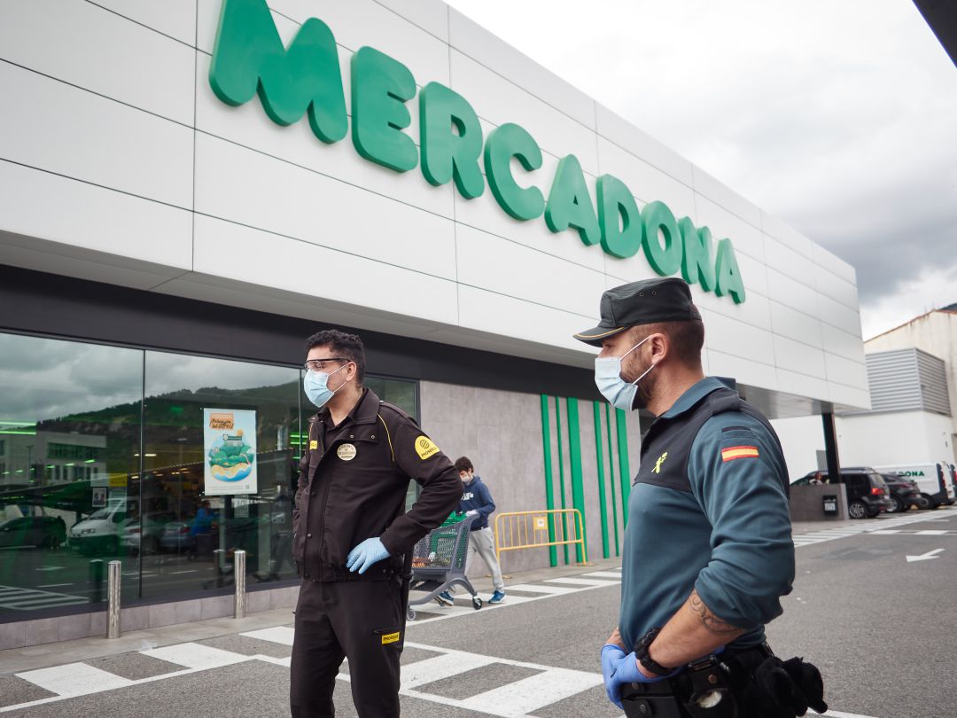 Un agente de la Guardia Civil y otro agente de seguridad privada, frente a la puerta de un gran supermercado durante el periodo de estado de alarma en España. Un agente de la Guardia Civil y otro agente de seguridad privada, frente a la puerta de un gran supermercado durante el periodo de estado de alarma en España.