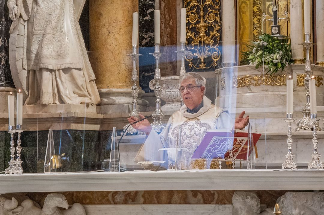 El rector de la Basílica de la Virgen de los Desamparados oficia misa tras una mampara de metacrilato para no llevar mascarilla El rector de la Basílica de la Virgen de los Desamparados oficia misa tras una mampara de metacrilato para no llevar mascarilla