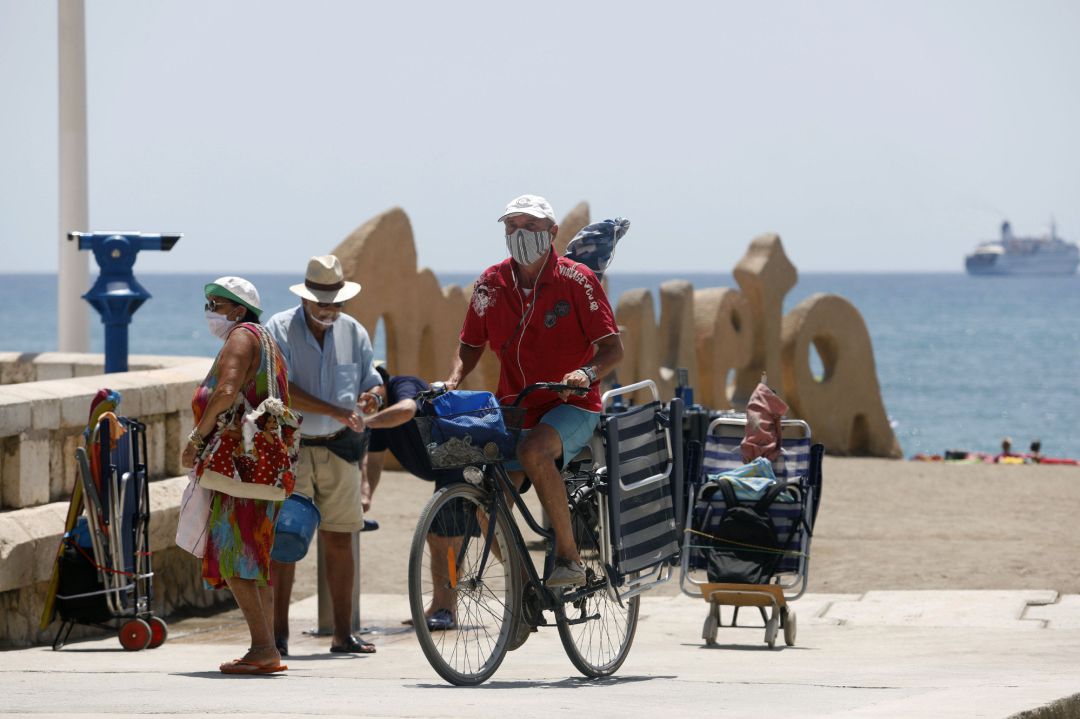 Bañistas con mascarillas en la playa de La Malagueta Bañistas con mascarillas en la playa de La Malagueta