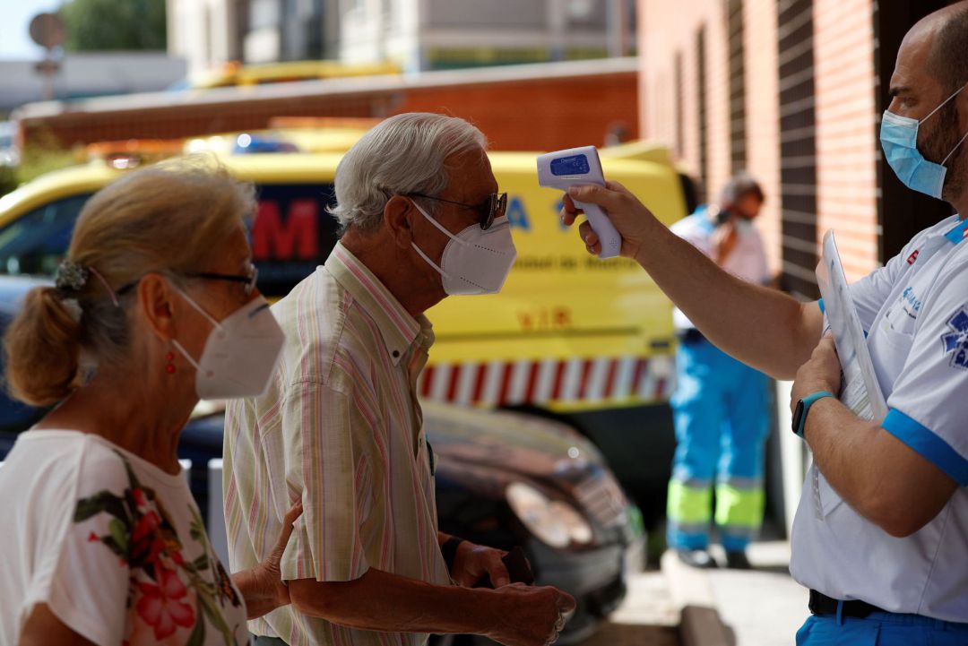 Un sanitario toma la temperatura Un sanitario toma la temperatura