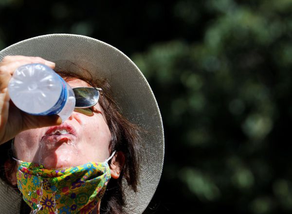 Una persona bebe agua protegida del sol en Córdoba