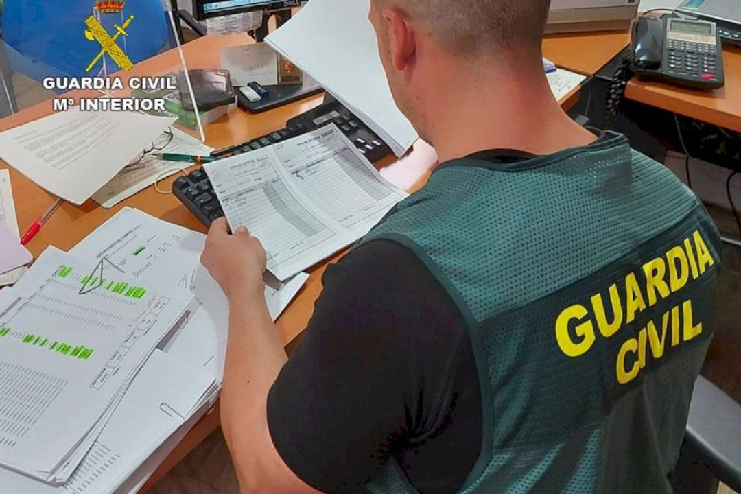 Agente de la Guardia Civil inspeccionando documentos Agente de la Guardia Civil inspeccionando documentos