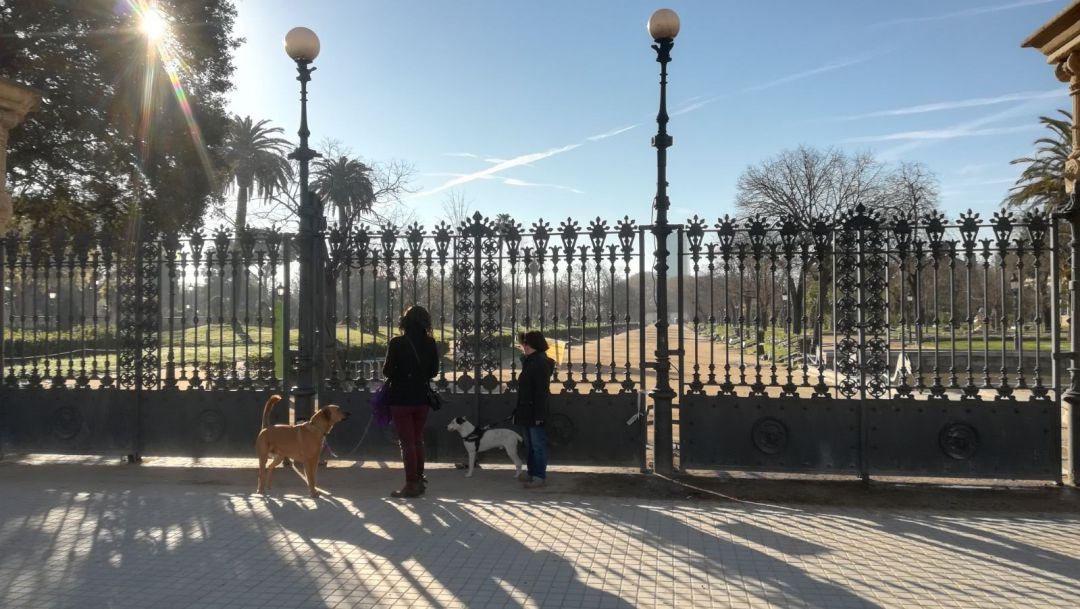 Dos mujeres pasean a sus perros por la entrada del Parc de la Ciutadella de Barcelona, cerrado Dos mujeres pasean a sus perros por la entrada del Parc de la Ciutadella de Barcelona, cerrado