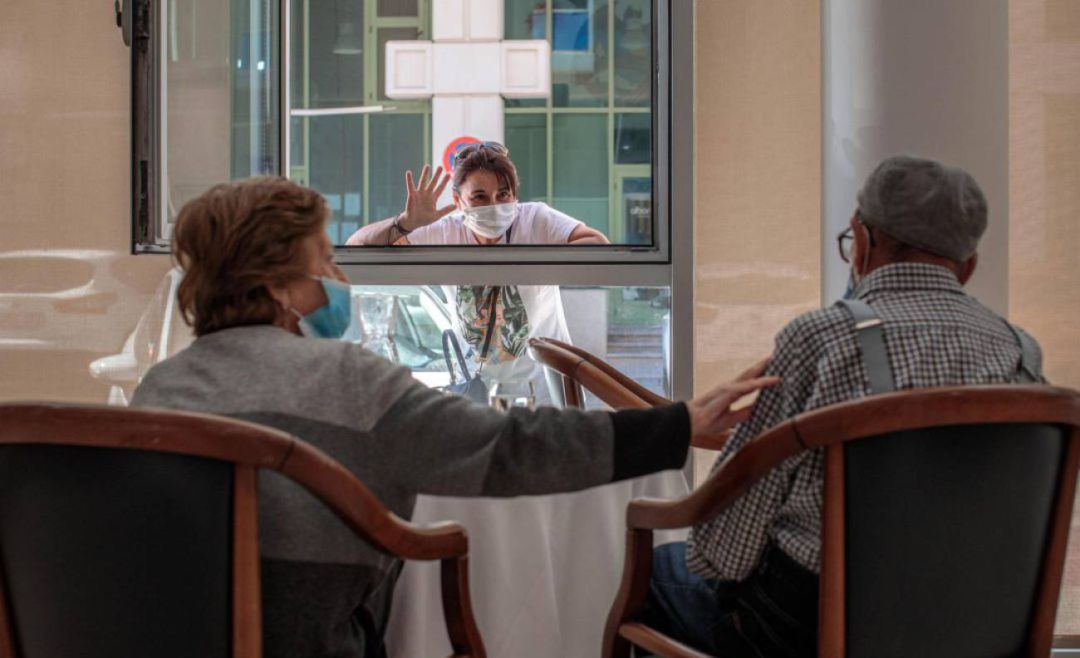 Una joven visita a su abuelo, aislado en una residencia Una joven visita a su abuelo, aislado en una residencia