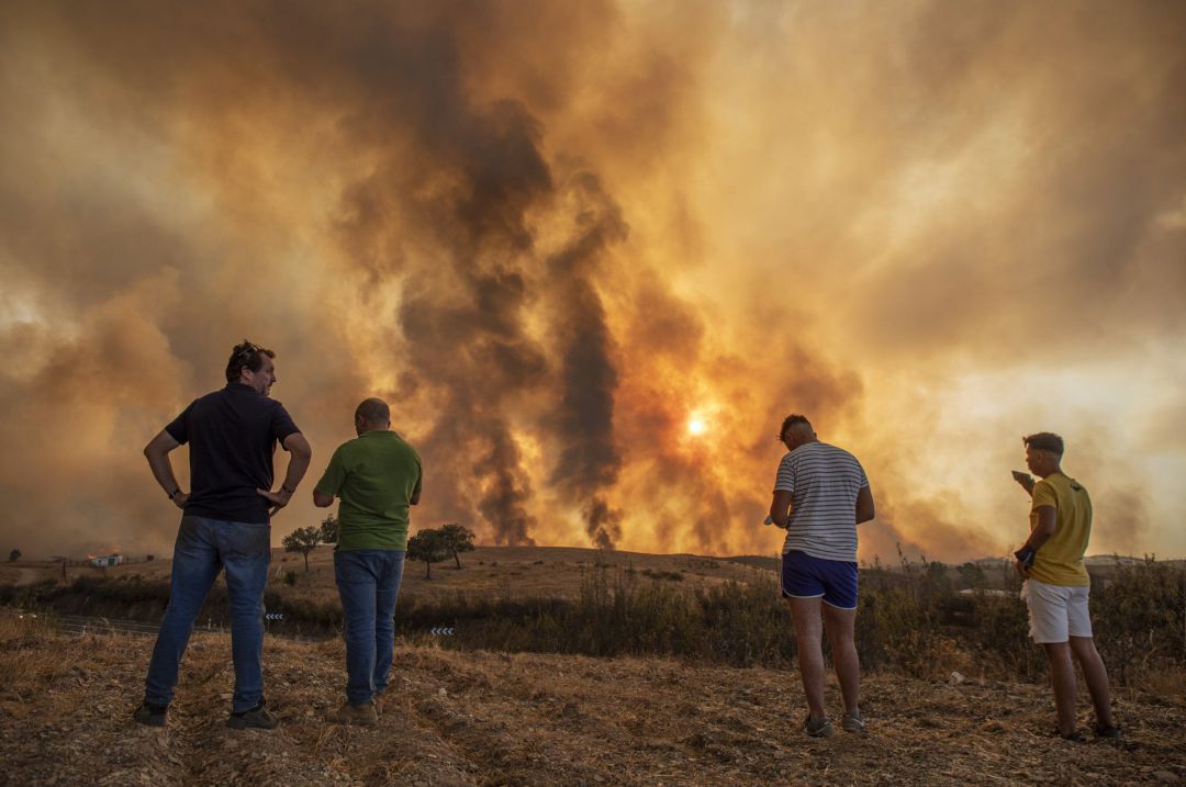 Vecinos contemplan el incendio de Almonaster.
Vecinos contemplan el incendio de Almonaster.