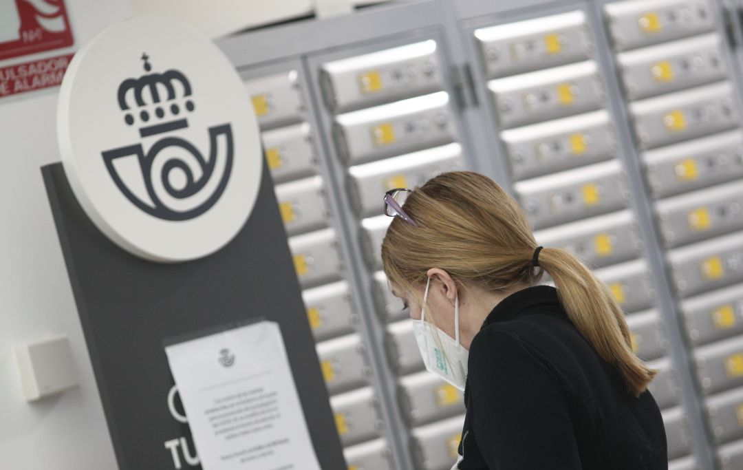 Una mujer en una oficina de Correos. Una mujer en una oficina de Correos.