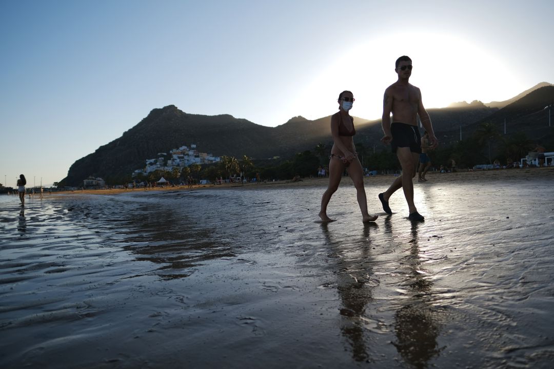 Dos personas pasean por una playa de las Islas Canarias Dos personas pasean por una playa de las Islas Canarias