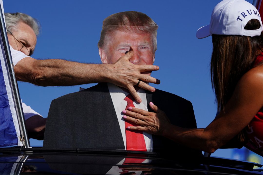 Los partidarios del presidente de Estados Unidos, Donald Trump, ajustan un recorte de cartón de Trump antes de participar en una caravana en Dunwood Los partidarios del presidente de Estados Unidos, Donald Trump, ajustan un recorte de cartón de Trump antes de participar en una caravana en Dunwood