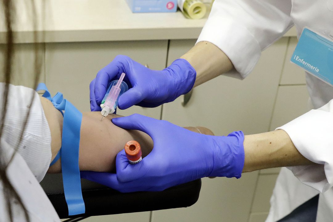 Un trabajador sanitario extrae sangre de una paciente para realizar el test serológico Un trabajador sanitario extrae sangre de una paciente para realizar el test serológico