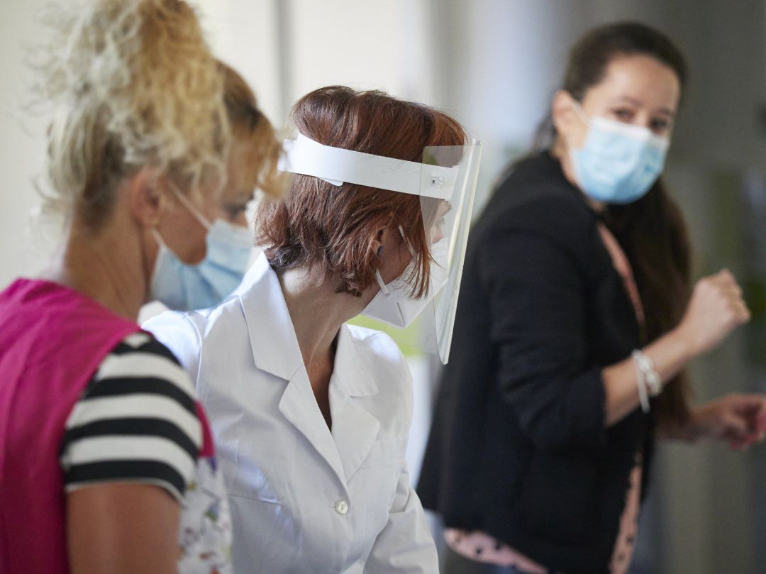 Personal docente con mamparas y mascarillas en un colegio Personal docente con mamparas y mascarillas en un colegio