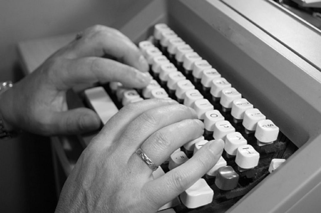 Mujer usando una máquina de escribir Mujer usando una máquina de escribir