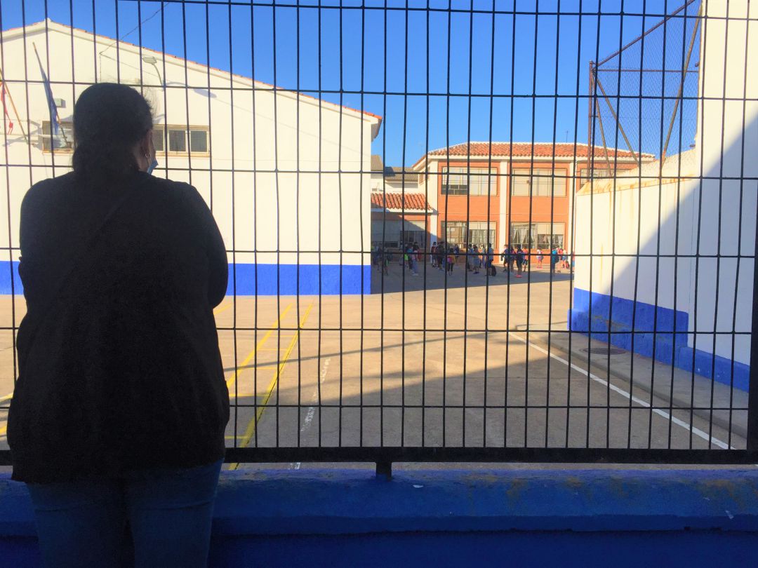 Una madre espera, desde la valla, a que los niños pasen al interior del colegio en Las Pedroñeras Una madre espera, desde la valla, a que los niños pasen al interior del colegio en Las Pedroñeras