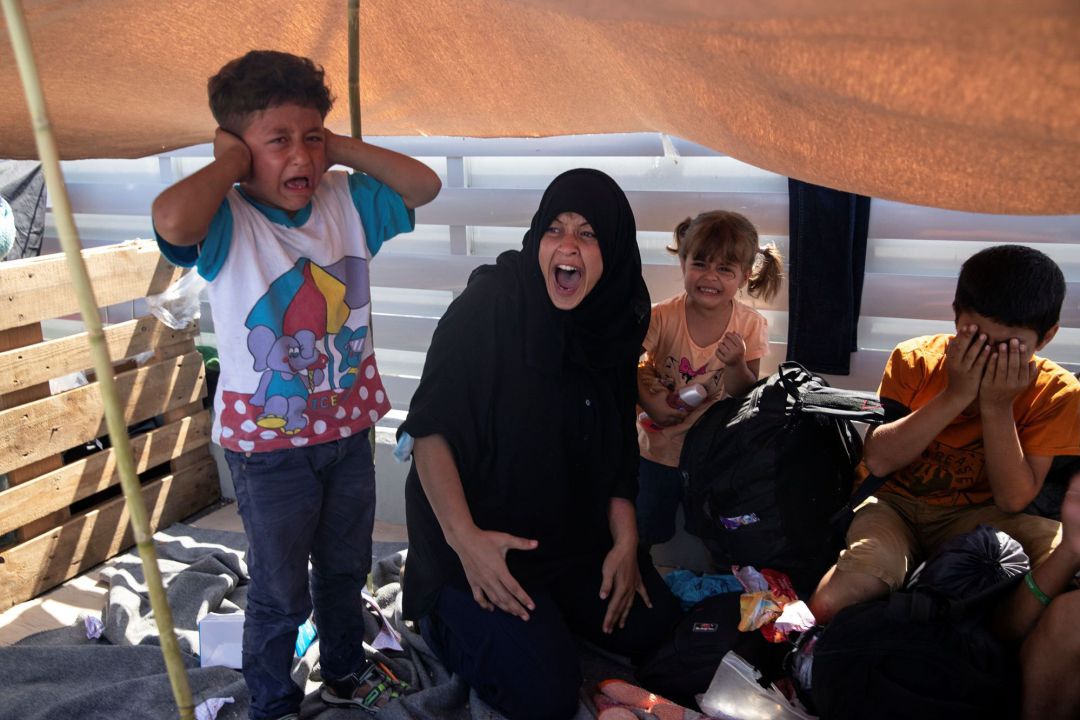 Woman and children react as refugees and migrants from the destroyed camp of Moria flee clash with riot police, on the island of Lesbos, Greece, 12, 2020. REUTERS Alkis Konstantinidis Woman and children react as refugees and migrants from the destroyed camp of Moria flee clash with riot police, on the island of Lesbos, Greece, 12, 2020. REUTERS Alkis Konstantinidis