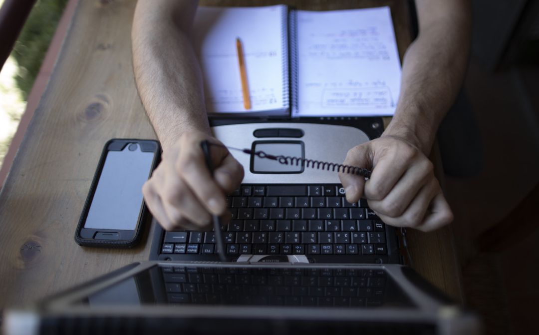 Un hombre teletrabajando desde su casa con un portátil. Un hombre teletrabajando desde su casa con un portátil.