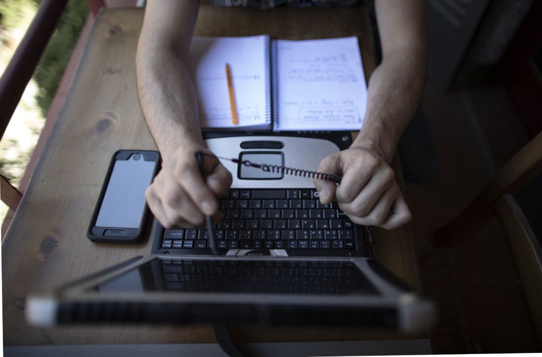 Un hombre teletrabajando desde su casa con un portátil. Un hombre teletrabajando desde su casa con un portátil.