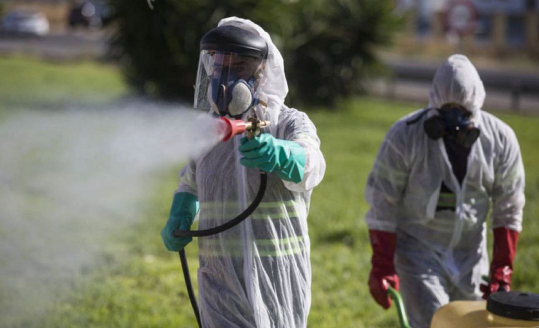 Dos técnicos fumigan en un terreno de Sevilla. Dos técnicos fumigan en un terreno de Sevilla.